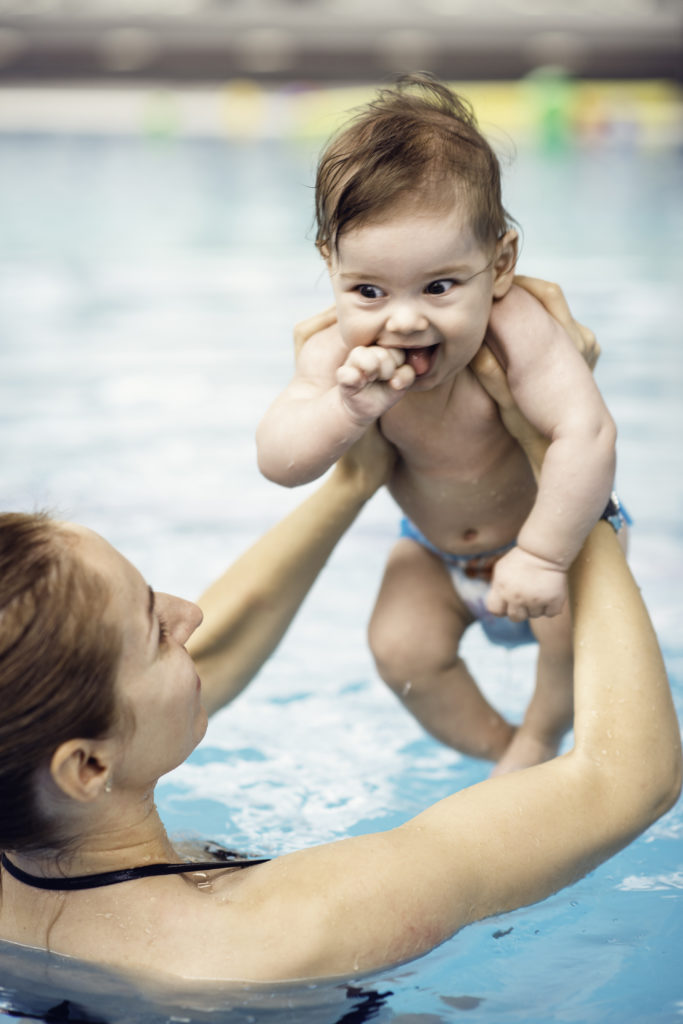 Cute baby boy with mother in swimming pool